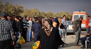 Uciekinierzy stłoczeni przed wejściem do główej bramy w Zaatari.
